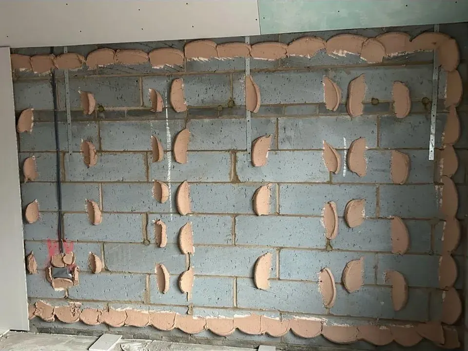 Dot and dab adhesive applied to blockwork ready for plasterboard