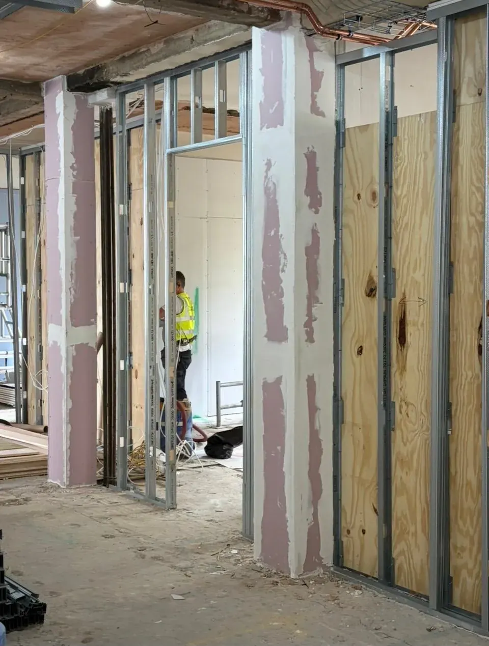 Fire-rated pink plasterboard partitions and plywood-backed walls
